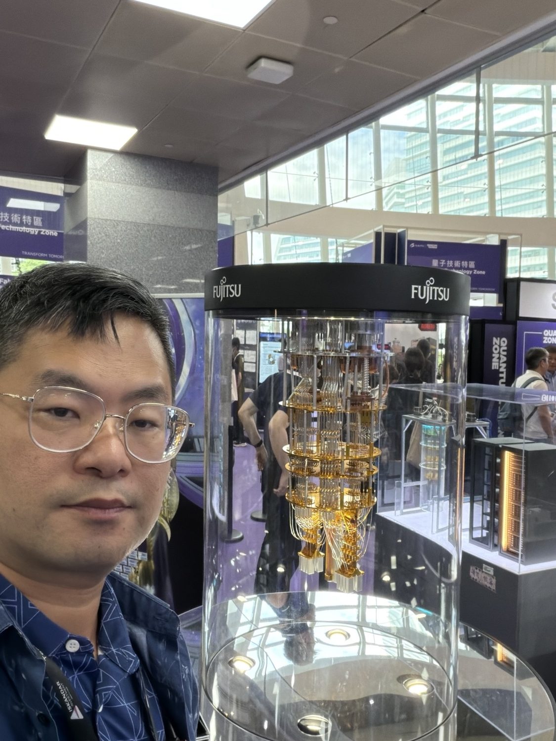 Joel Lin beside an exhibited quantum computing system